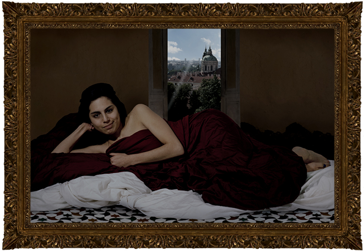 A woman lying on a bed wrapped in a sheet. She is holding the sheet to her chest and smirking.