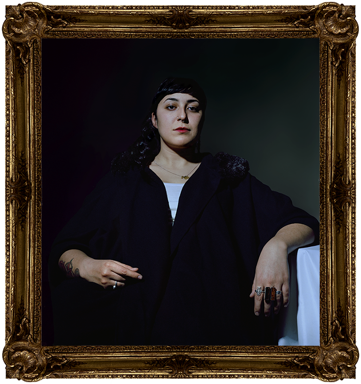 A person looking at the camera sternly. They are posed as though they are important.