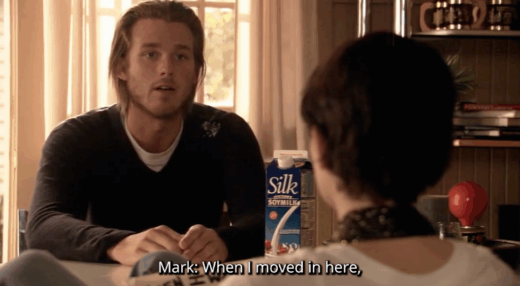 A white man sitting at a table. The subtitle text reads, "When I moved in here,"