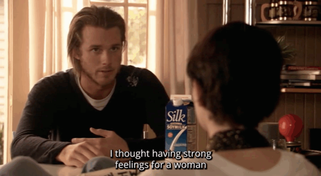 A white man sitting at a table. The subtitle text reads, "I thought having strong feelings for a woman"