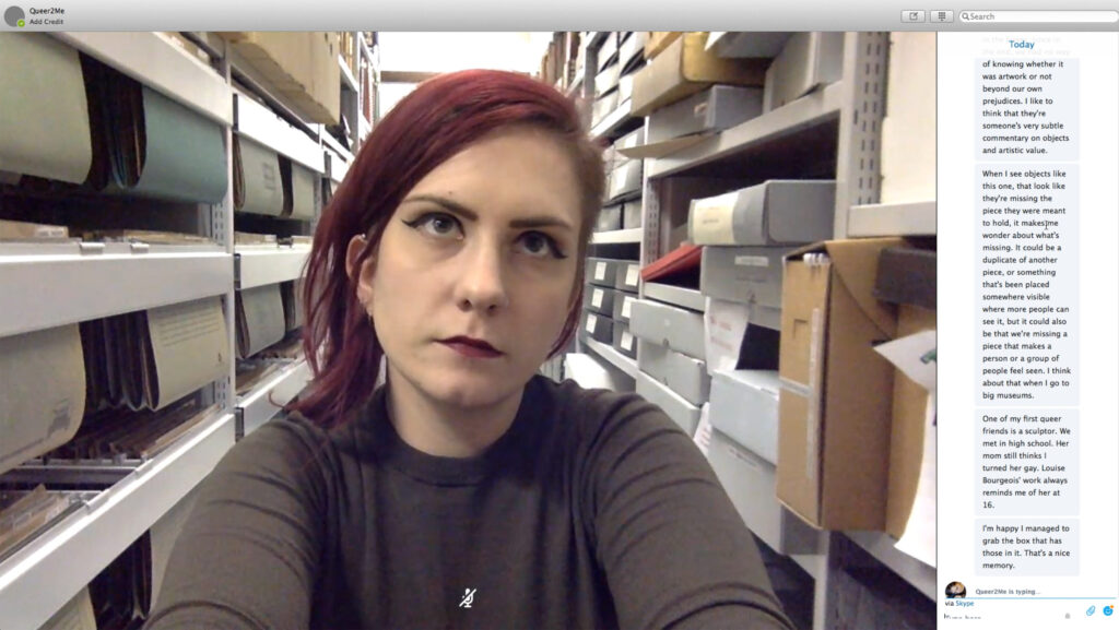 The artist on a skype call, looking upward as though thinking.